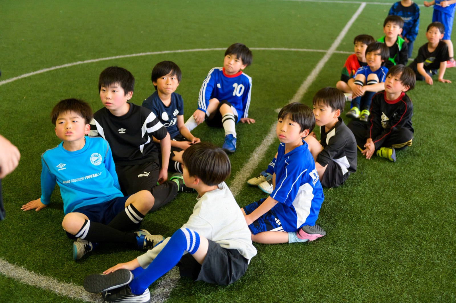 子どもたちと円陣で向き合う代表・西口